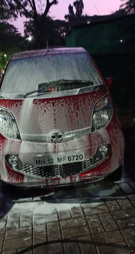 Evening wash of a hatchback with foam rinsing off the bonnet